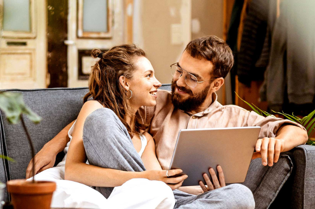 Mann und Frau am Sofa mit Laptop