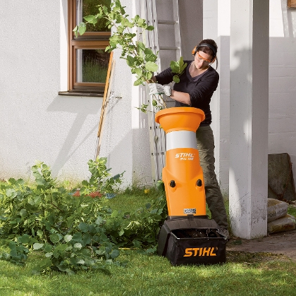 Frau häckselt Gartenabfälle mit einem Häcksler von STIHL