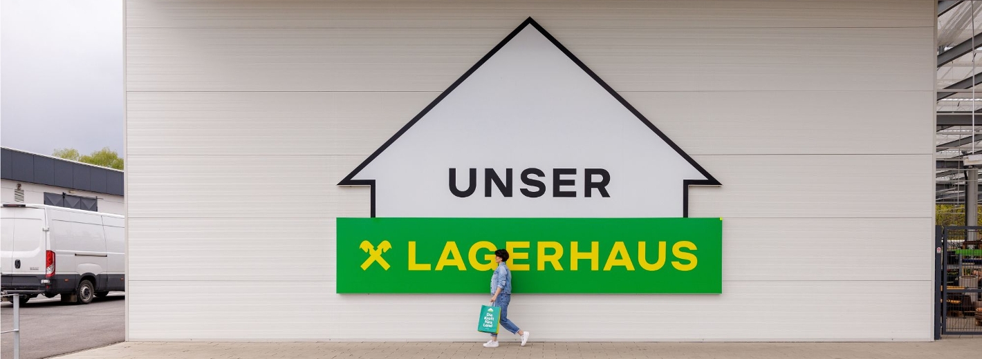 Großes "Unser Lagerhaus" Logo auf weißer Wand.