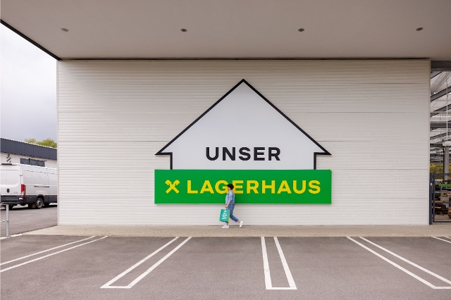 Großes "Unser Lagerhaus" Logo auf weißer Wand.