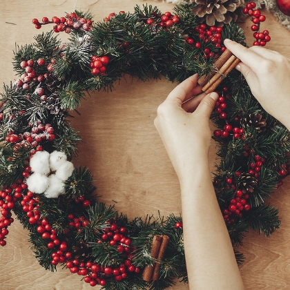 Hände die einen Adventkranz binden