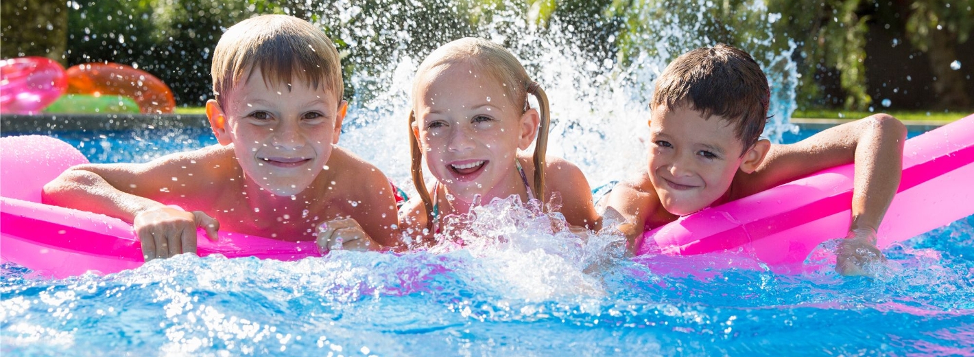 Kinder, die auf einer Luftmatratze im Pool liegen und Spaß haben