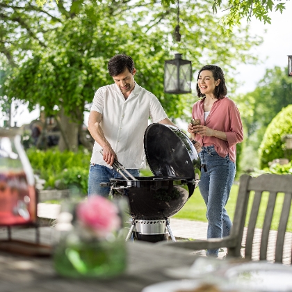 Mann und Frau grillen im Garten