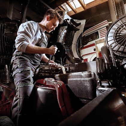 KFZ Mechaniker mit Werkstoff-Arbeitskleidung