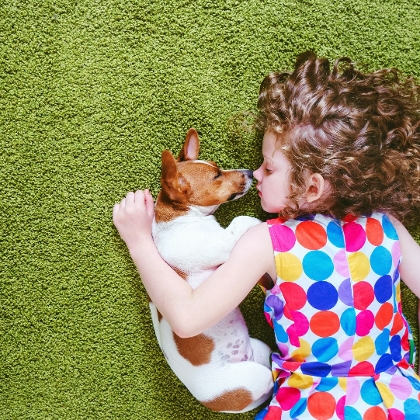 Kleines Mädchen kuschelt mit Hund